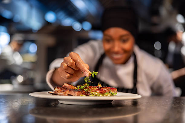 Close-up on a chef decorating a plate in a commercial kitchen at a restaurant - Fine dining concepts